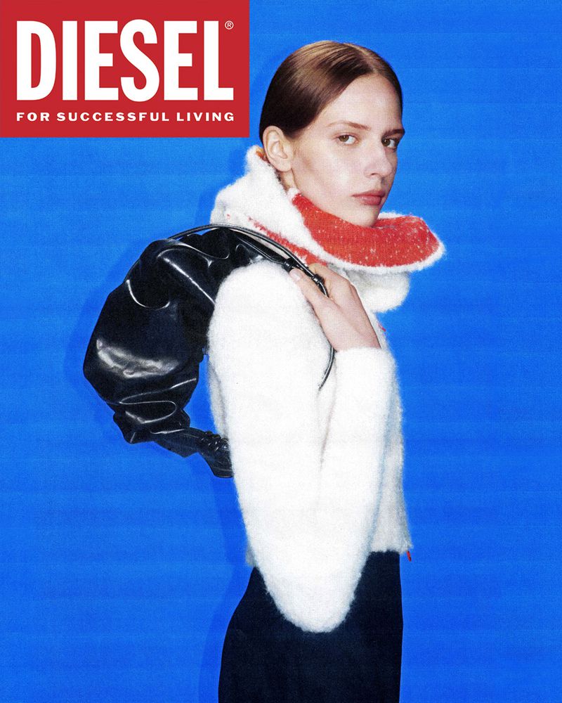 Fashion shot of an adult woman wearing a white furry jacket with black bag against a blue backdrop; Diesel logo is visible.