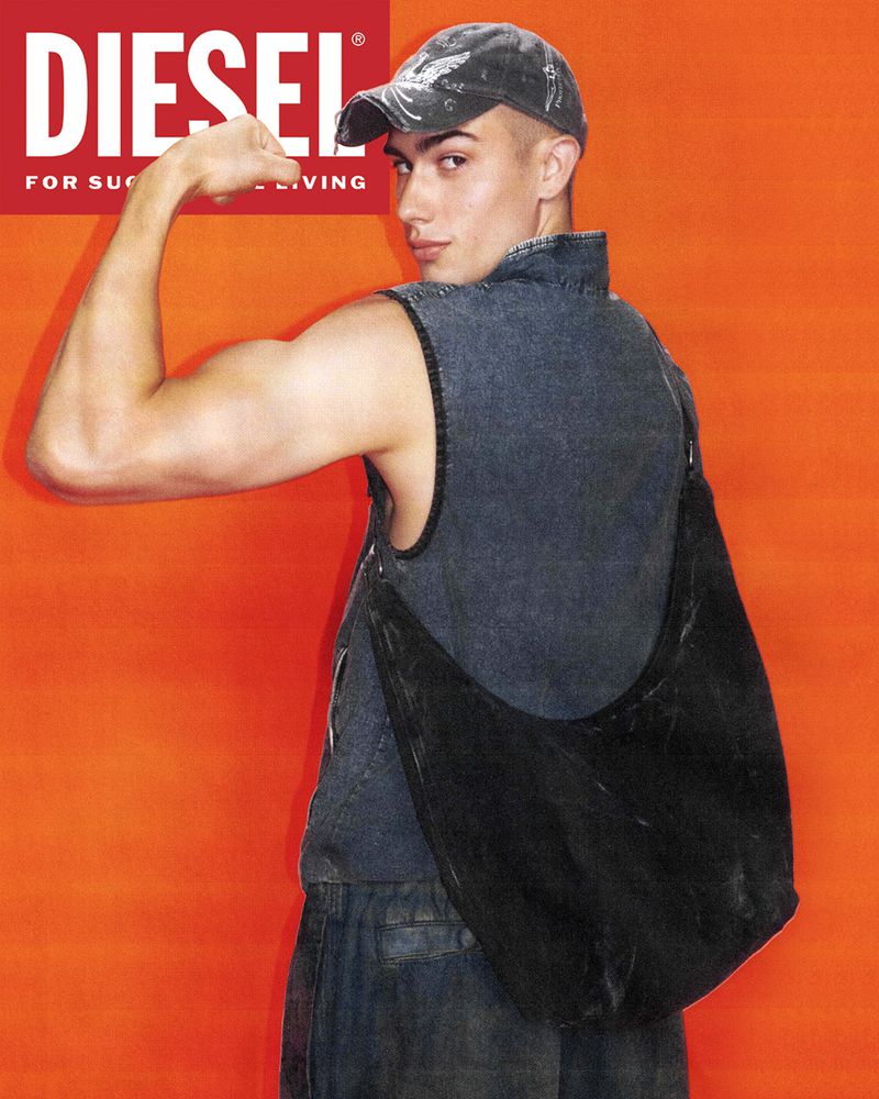 Man in denim vest with cap poses against an orange backdrop, showcasing bicep and shoulder bag, with Diesel logo visible.