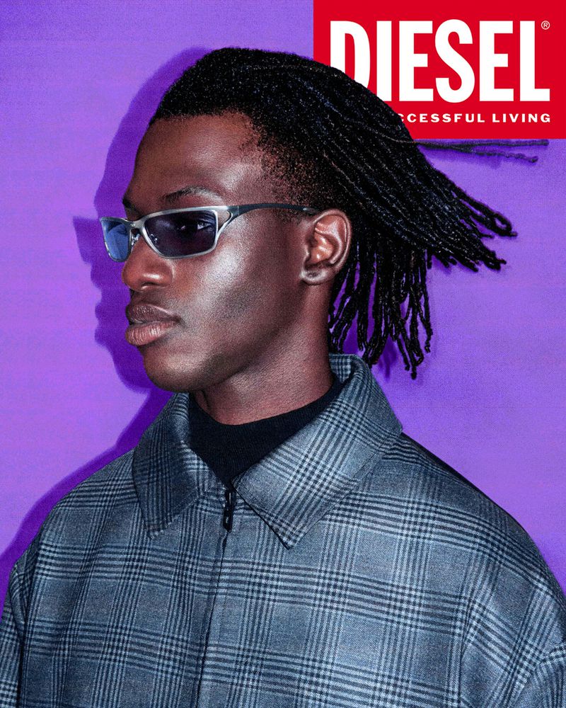 Headshot of a dark-skinned adult male model wearing sunglasses and a gray plaid jacket, set against a solid purple backdrop with a Diesel logo.