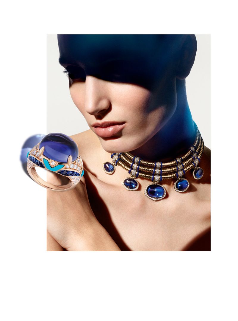 A woman in a close-up shot wears a blue stone necklace and a ring in a beauty and fashion editorial style.
