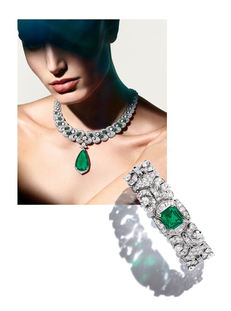 Close-up of a woman showcasing a diamond and emerald necklace and bracelet against a clean white background, emphasizing luxury and elegance.