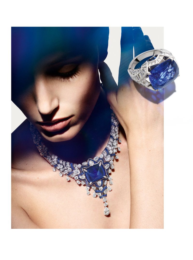 Woman wearing a sapphire and diamond necklace with a large sapphire ring. Jewellery shoot for fashion or beauty with cool blue lighting.