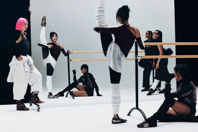 Group of young women in athletic wear strike poses and stretch in bright studio with ballet barre, creating a fitness fashion editorial.
