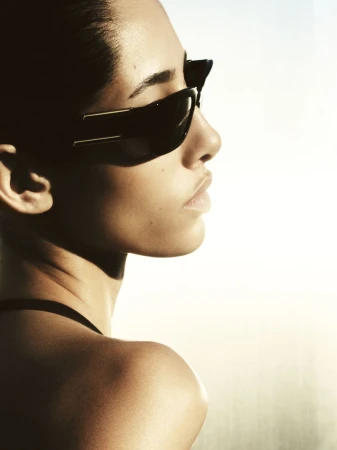 Model Yasmin Wijnaldum wearing black sunglasses in profile view for the Revolve FWRD 2025 campaign, photographed by Yulia Gorbachenko.