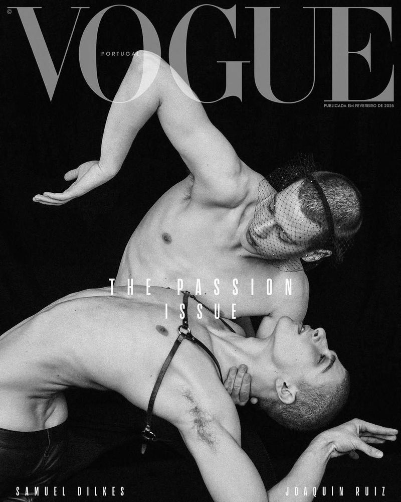 Fashion magazine cover featuring two shirtless adult men in black and white; one with a net head covering, dramatic pose in studio.