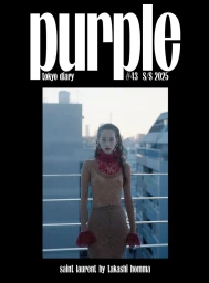 Model wearing a sheer textured dress with red lace collar and cuffs standing on a rooftop against city buildings.