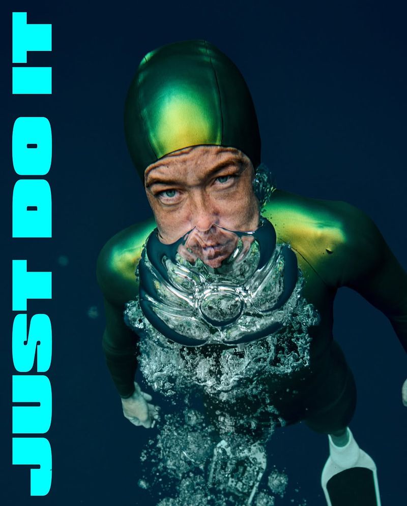 A man in a wetsuit underwater surrounded by bubbles, with the text 'Just Do It' vertically along the left side of the image.