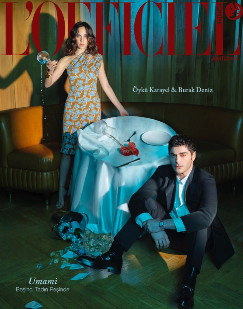Magazine cover features a woman in a patterned dress holding a wine glass and a man in a suit seated with a spilled bottle nearby.