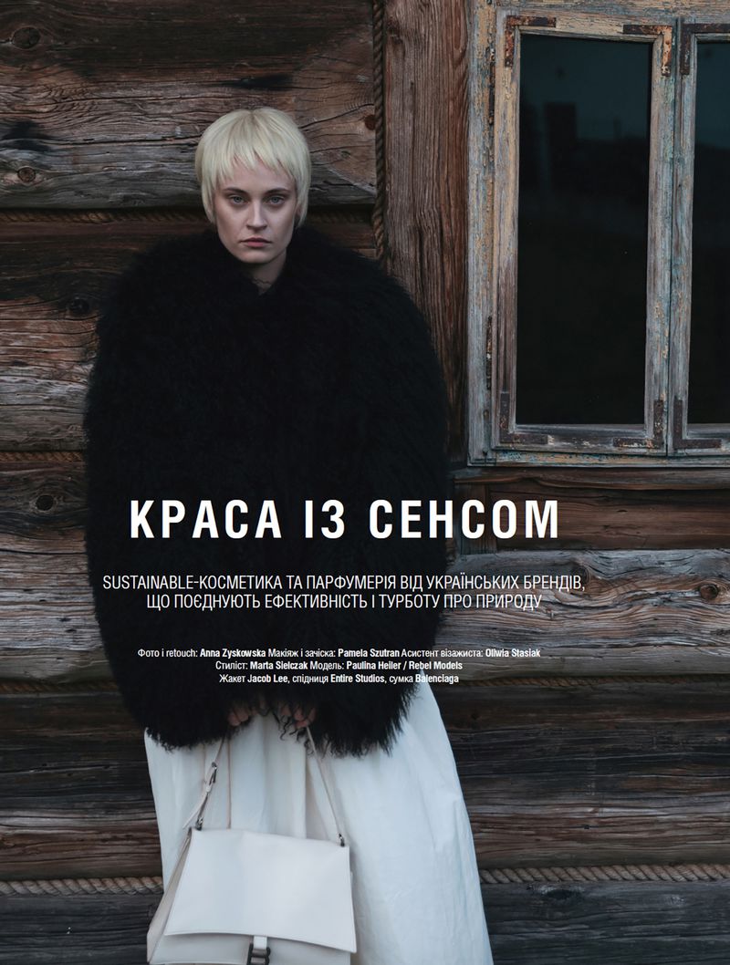 A blonde woman models a black fur coat and carries a white bag, set against a rustic wooden backdrop with Ukrainian ad copy overlay.