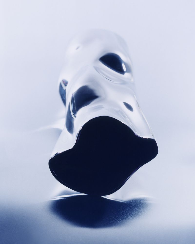 Abstract view of light and dark blue liquid on a white surface, creating a surreal and intriguing visual texture and form.