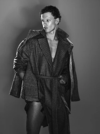 Monochrome portrait of male model Jamy Tobias wearing a patterned coat for The Collector Magazine editorial by Mattia Guolo.