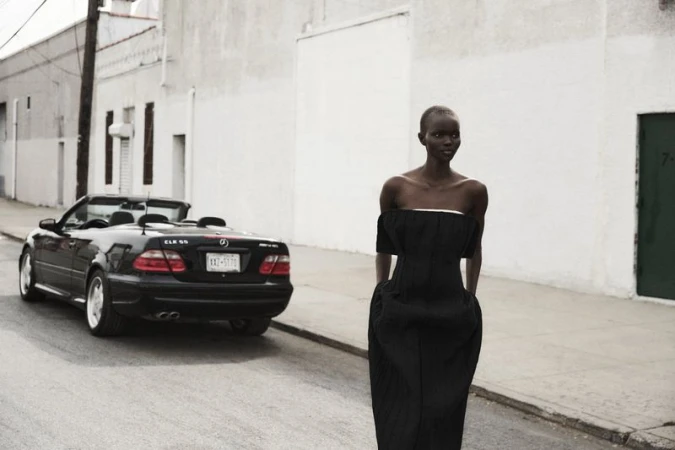 Elegant Black Woman in Designer Dress Poses on City Street Next to Black Mercedes-Benz Convertible, Fashion Editorial Photography.