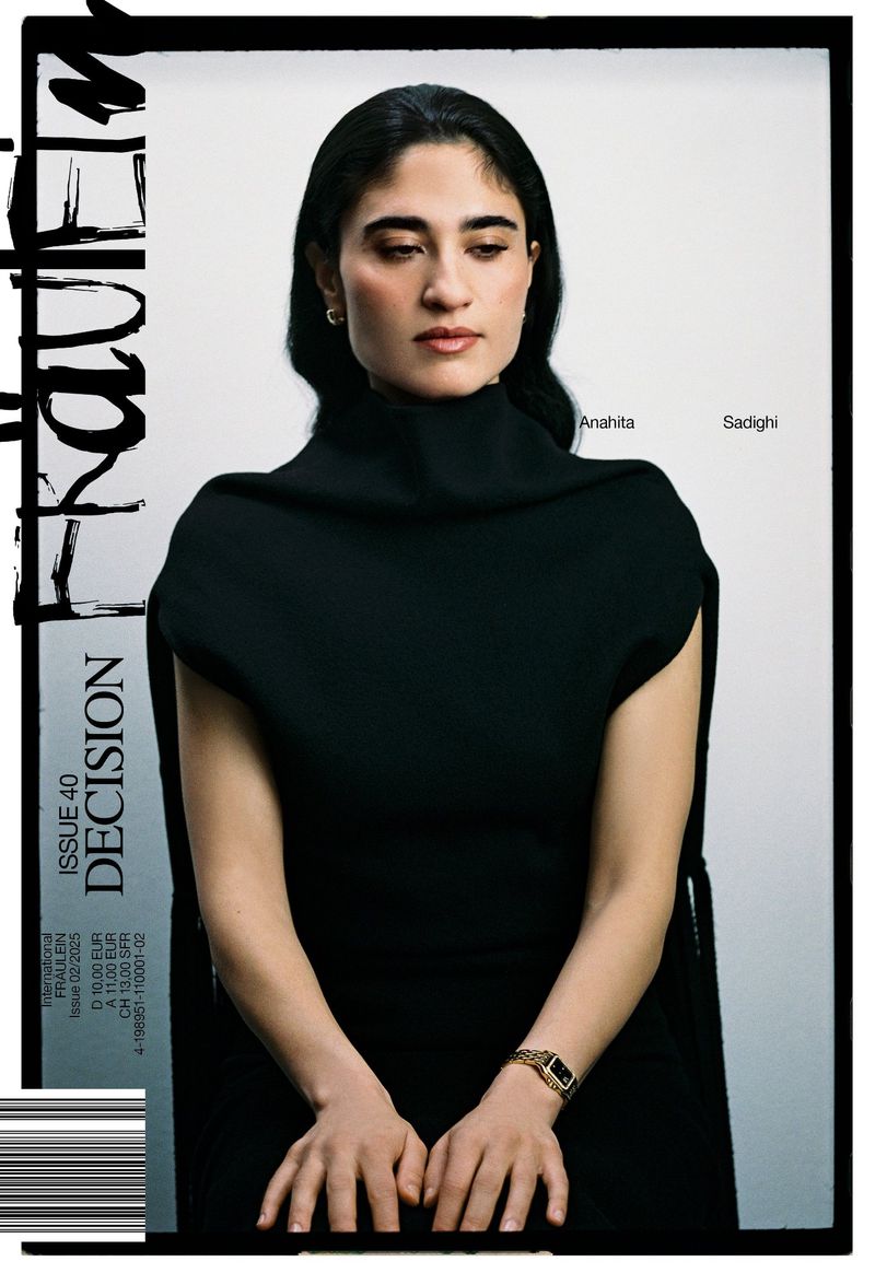 Editorial fashion shot: a woman wearing a black dress and gold watch sits in front of a white background, portrait framed by a magazine cover.