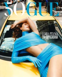 Camila Pitanga reclining on a yellow taxi roof in Copacabana wearing a bright blue top and skirt for Vogue Brasil February 2025