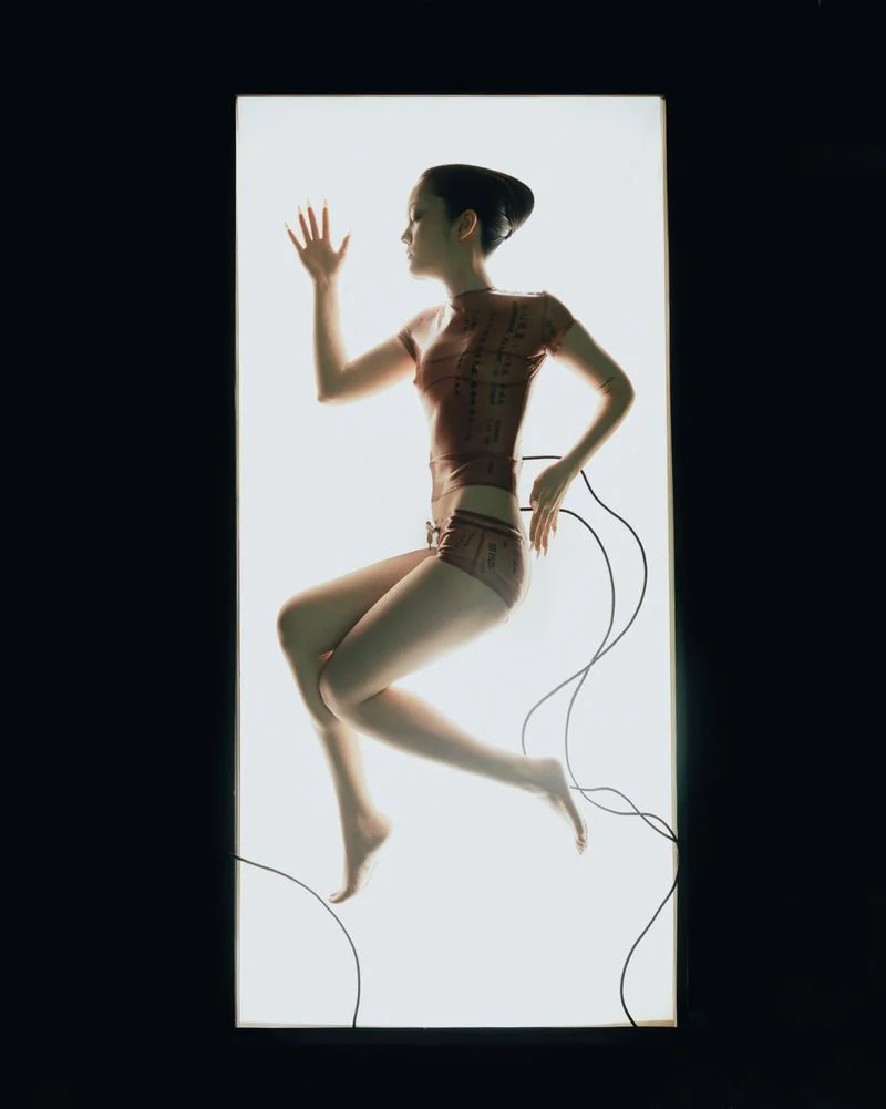 Yvette Chau posed inside an illuminated white light box with trailing black cables for The Creature editorial.