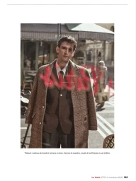 Model Thibaud Charon wearing a brown tweed coat and suit standing on a Parisian street with red overlay lettering.