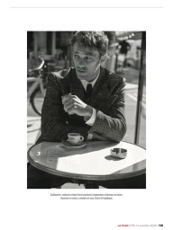 Model Guillaume Babouin seated at an outdoor café table wearing a herringbone jacket with an espresso cup and ashtray.
