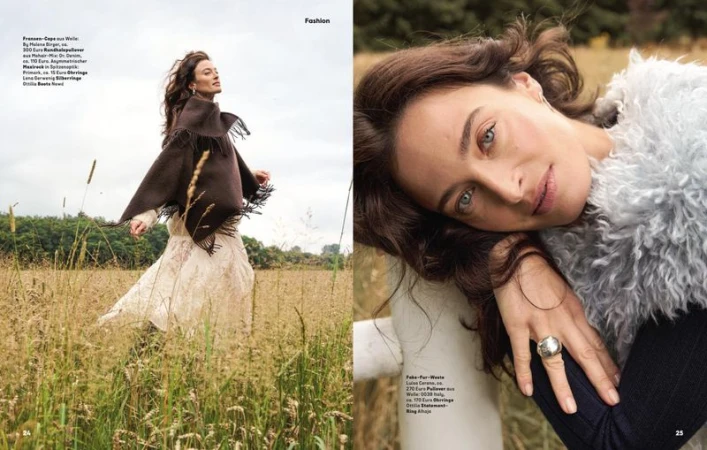 Double page spread featuring a female model in an outdoor field wearing knitwear and a cape for an editorial by Frank Widemann.