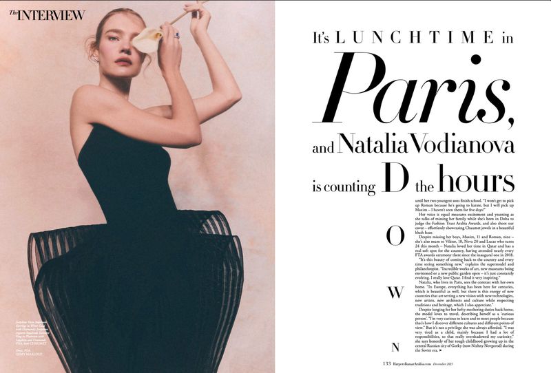 Natalia Vodianova poses in a strapless black dress with a white flower in front of her eye in a magazine editorial spread.
