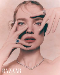 Natalia Vodianova posing with hands framing her face wearing a sapphire diamond ring and necklace for Harper's Bazaar Arabia.