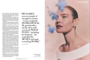 Close-up portrait of a woman wearing an off-shoulder white top with a diamond earring next to a column of magazine text.
