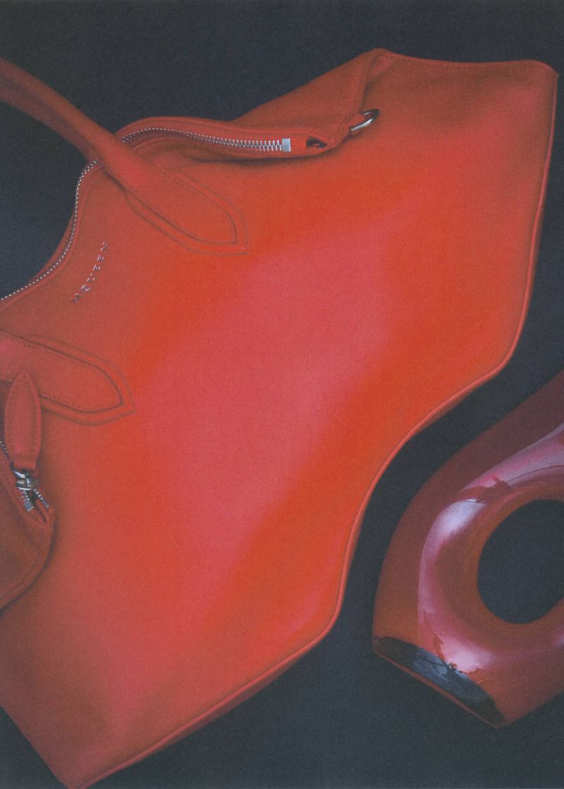 Red leather handbag and high heel pump shoe on a dark backdrop. Fashion accessory still life with purse and footwear.