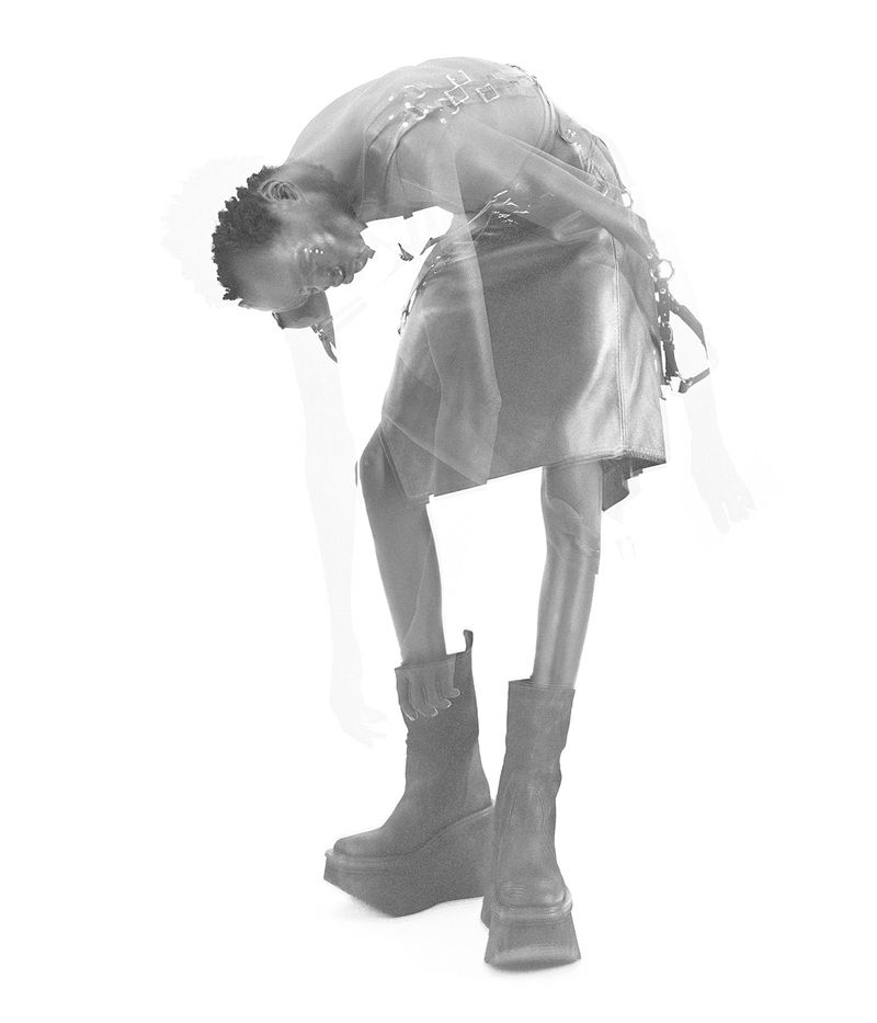 Adult fashion model poses in a silver metallic skirt and black platform boots against a white background with a blurred effect.