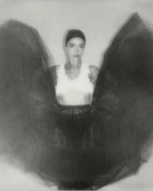 Asha Banks wearing a white top and dramatic winged black tulle skirt in a monochrome portrait for Schön Magazine.