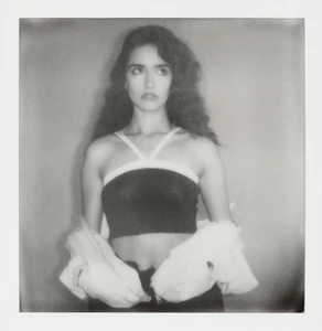 Portrait of Asha Banks wearing a halter top and jacket against a plain background