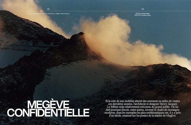 Snow-covered mountain peaks are partially shrouded in clouds under a blue sky, a striking landscape featured in a magazine spread.