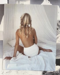 Blonde woman with braided hair seated on a white bed wearing white underwear