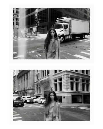 Black and white fashion portrait of a woman with long dark hair wearing a sleeveless dress, standing on a city street with buildings and cars.