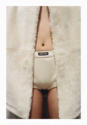 Close-up crop of a model wearing ribbed cream underwear and a fluffy cream coat for Vogue Polska NYC.