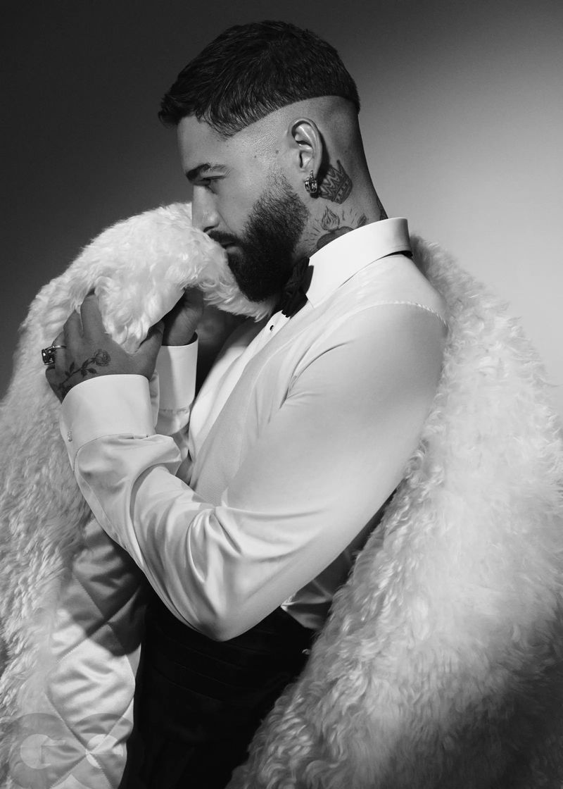 Black and white portrait of a bearded adult male in formal wear, featuring a white shirt, black bow tie, and a textured white coat.