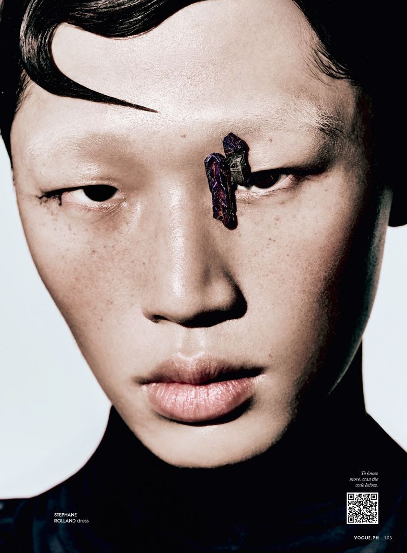 Close-up beauty shot of a person with an eyebrow adornment, against a stark studio backdrop. Focused on fashion and aesthetic.