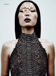 Model Gwonho Oh with a white snake skeleton motif over the face wearing a textured dark halter top against a white studio background.