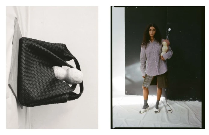 Editorial shot of a brunette woman in an oversized striped shirt holding an abstract object in a photo studio with a black and white backdrop.
