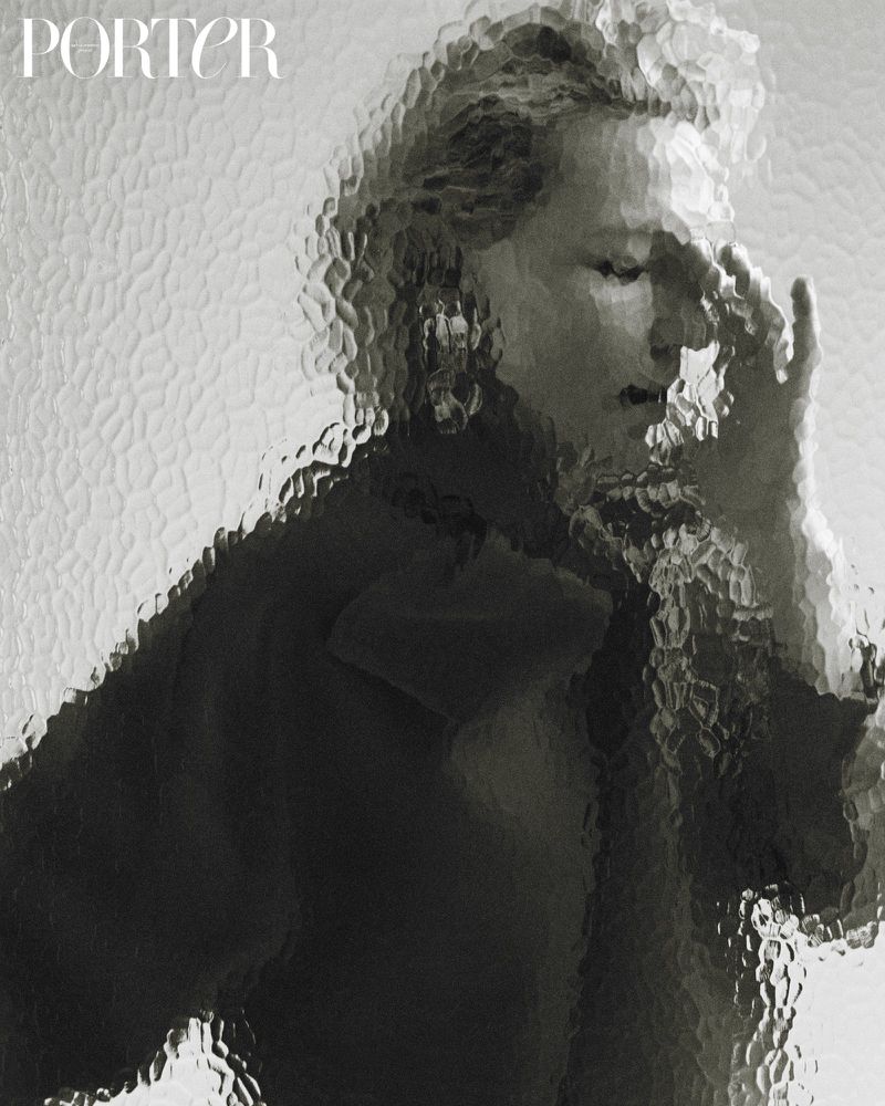 Monochromatic portrait of a model with a hand near her face behind textured glass with the magazine title 'Porter' visible.