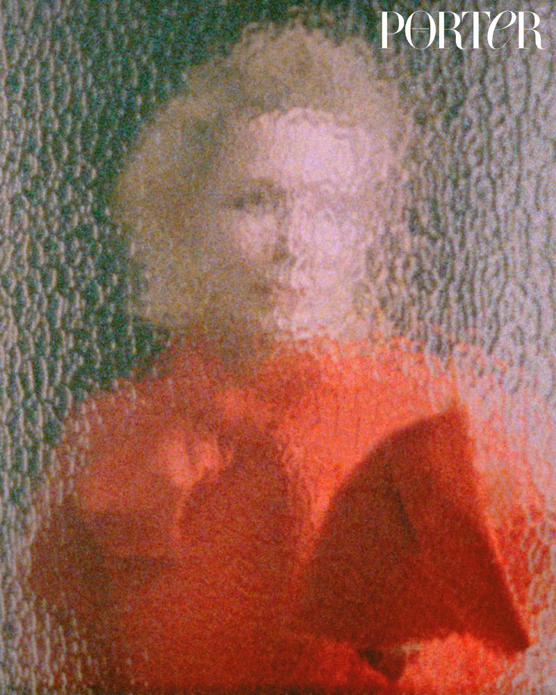 Abstracted portrait of a person in a red top behind textured glass, creating a blurred and dreamy effect, with 'PORTER' text visible.