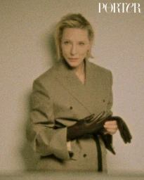 Portrait of Cate Blanchett wearing a structured grey blazer and dark gloves for Porter Magazine