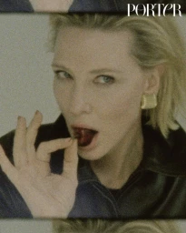 Portrait of Cate Blanchett eating a cherry for Porter Magazine, wearing a dark jacket and gold earrings
