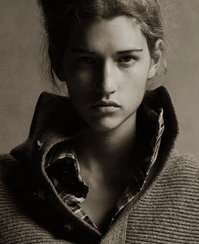 Monochrome portrait of a woman in a collared shirt and sweater, softly lit, with focus on her face and simple hair.