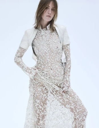 Rose Byrne wearing an intricate white lace dress and white leather jacket against a light studio backdrop for Marie Claire Australia.