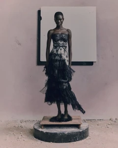 Model Chol Khan standing on a pedestal in a strapless tiered black lace and tulle gown for the Erdem Pre-Fall 2026 lookbook.