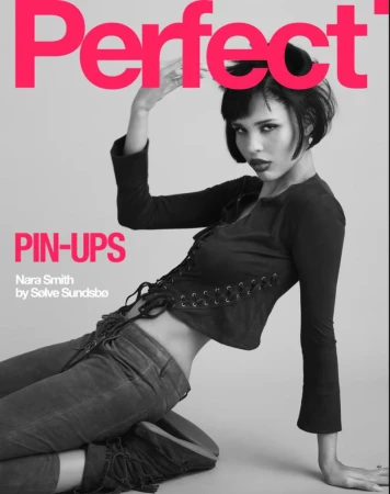 Fashion magazine cover featuring a model, Nara Smith, in a black lace-up top and grey jeans, posing against a grey background.