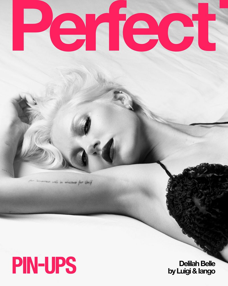 Monochrome portrait of Delilah Belle lying down wearing a black top against a white background with bold pink text at top and bottom.