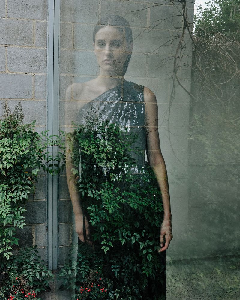Woman in a sequined dress posing with nature elements, creating a composite image against a textured concrete wall backdrop.