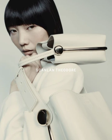 Fashion shot featuring an Asian woman model showcasing a white handbag and purse from Scanlan Theodore, set against a soft, neutral background.