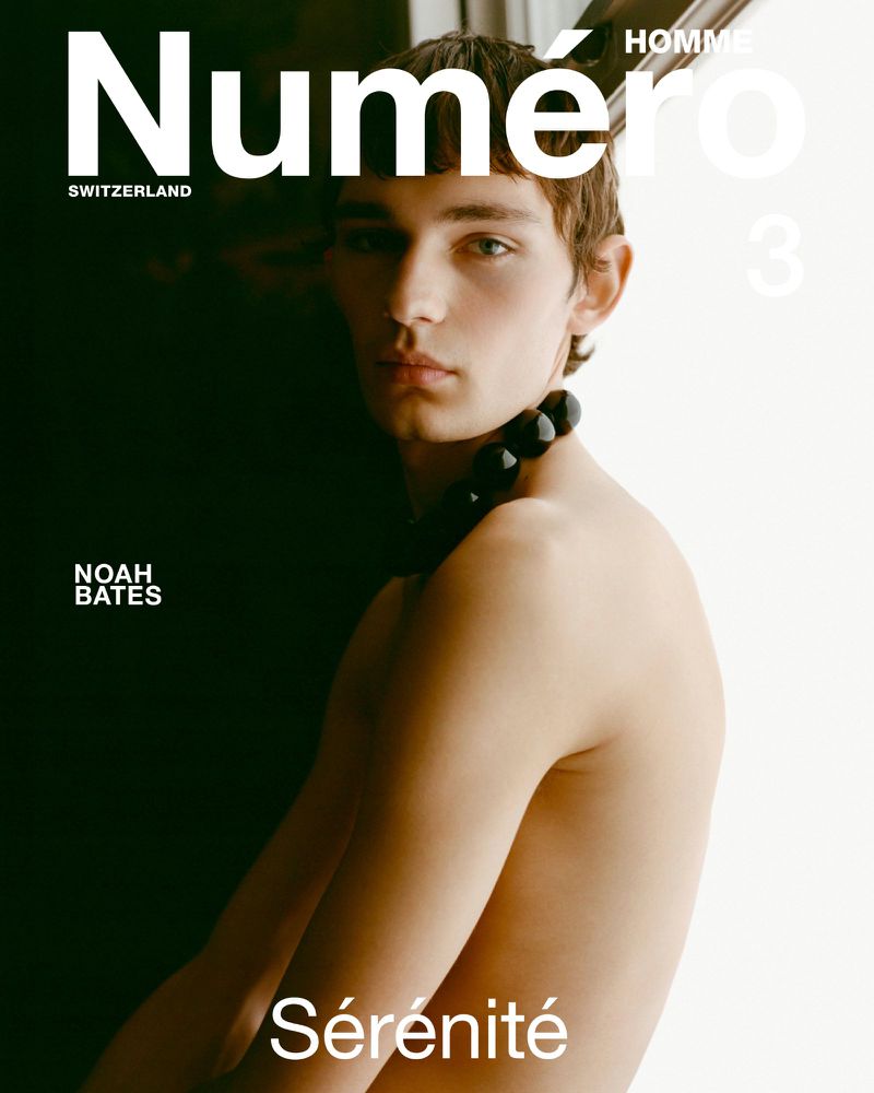 Numero Homme magazine cover featuring a bare-chested adult male model wearing a beaded necklace on a split dark-and-light background.