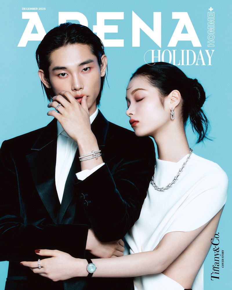 Arena Homme+ magazine cover featuring an adult couple in formal wear and jewelry against a light blue background for the holiday season.